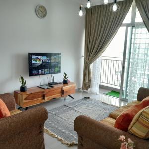 a living room with two couches and a flat screen tv at Dlake Putrajaya Homestay in Putrajaya