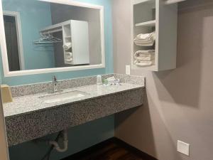 a bathroom with a sink and a mirror and towels at RIVERSIDE MOTEL 