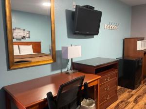 a room with a desk with a mirror and a desk with a television at RIVERSIDE MOTEL 