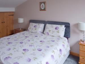 a bedroom with a bed with purple flowers on it at Valley View - 29530 in Scotforth