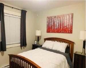 a bedroom with a bed and a painting on the wall at A Cozy Family get away suite in South Nanaimo in Nanaimo