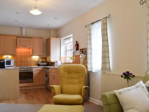 a kitchen with a chair and a couch in it at Bards Well in Stratford-upon-Avon