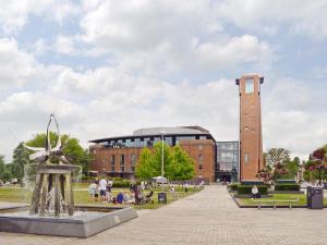 a building with a clock tower and a statue at Bards Well in Stratford-upon-Avon