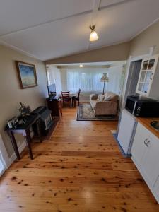 a kitchen and living room with a wooden floor at Shelton-Lea in Katoomba