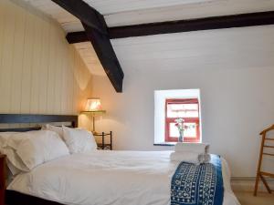 a bedroom with a white bed and a window at Gerlan in Tregaron