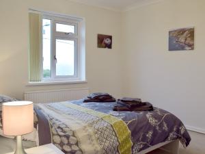 1 dormitorio con cama y ventana en Ty Howton, en Clydach