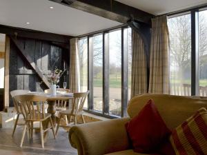 uma sala de estar com uma mesa e um sofá em The Cart Lodge-e3568 em Uggeshall