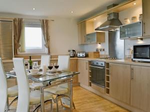 a kitchen with a table and chairs in a kitchen at Waters Edge in Llanelli