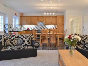 sala de estar y cocina con sofá y mesa en Maes Rheidol, en Capel Bangor