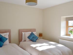 1 dormitorio con 2 camas y almohadas azules en Holgates Granary en Pendleton