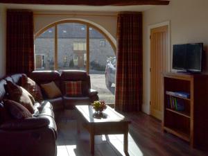 sala de estar con sofá y TV en Holgates Granary en Pendleton