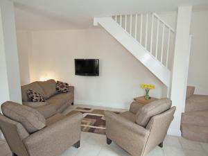 a living room with two chairs and a tv on the wall at Wisteria Cottage - E5094 in Chapel Saint Leonards