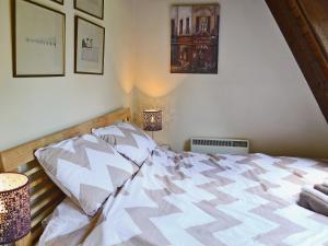 a bedroom with a bed and two lamps and pictures at Crown Cottage in Hartest