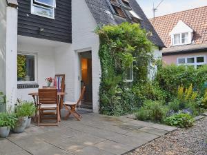 a patio with a table and chairs next to a house at Crown Cottage in Hartest