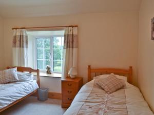 a bedroom with two beds and a window at No 2 Flowery Bank in Malton