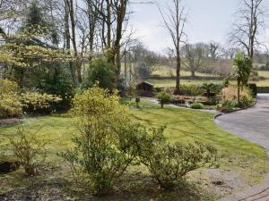 a garden with trees and bushes and a road at Riverside in Carlyon Bay