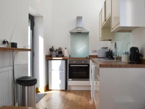 a kitchen with white cabinets and a stove top oven at The Granary in Criccieth