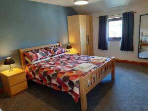 a bedroom with a bed with a colorful bedspread at Wickhams View in Keswick