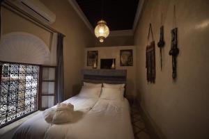 a bedroom with a white bed with a window at Riad AL Bahi in Rabat