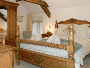 ein Schlafzimmer mit einem großen Holzbett mit weißen Kissen in der Unterkunft Orchard House in Parkham