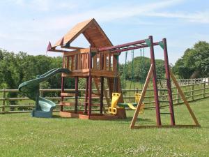 a playground with two slides and a swing at Orchard House in Parkham