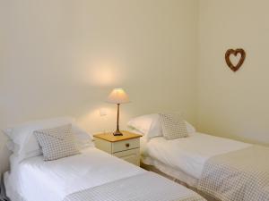 two twin beds in a room with a heart on the wall at The Steading At Nabny in Dundrennan