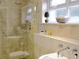 baño con lavabo y aseo y ventana en The Steading At Nabny en Dundrennan