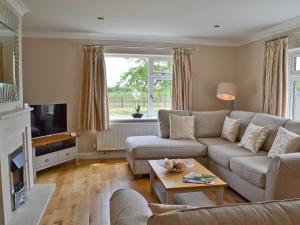 a living room with a couch and a tv at Henrys Bungalow in Anderby