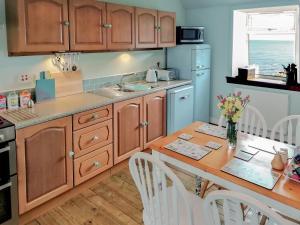 a kitchen with wooden cabinets and a table with chairs at The Lucken in Auchmithie