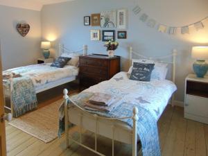 a bedroom with two beds and a dresser at The Lucken in Auchmithie