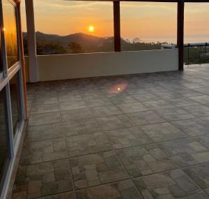 a view of a patio with a sunset in the background at Hotel Punta del Sol in Zipolite