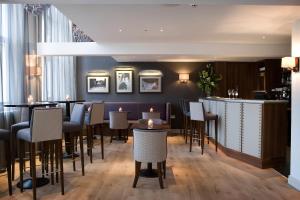 a restaurant with tables and chairs and a bar at Castle Hotel & Apartments in Lincoln