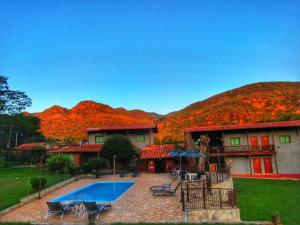 a resort with a swimming pool and mountains in the background at Pousada Mandalla in Serra do Cipo