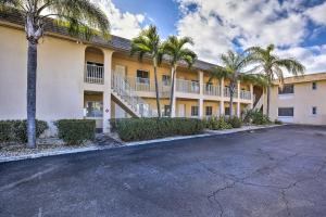 a parking lot in front of a building with palm trees at Walk to Beach and Dining Sunny St Pete Condo! in St Pete Beach