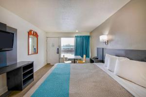 a hotel room with a bed with a television and a desk at Motel 6 Byron, Ga in Byron