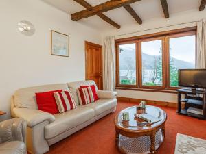 a living room with a couch and a tv at Creagan Ruadh in Kintail