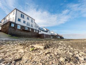 a building sitting on top of a rocky beach at Shoreline in Appledore