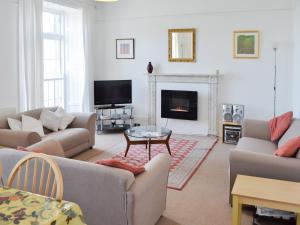 sala de estar con sofás, TV y chimenea en St Marys House, en Penzance