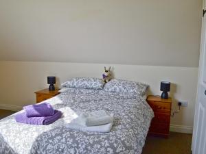 una cama con almohadas y un animal de peluche sentado en ella en Dale View Barn en Lusby