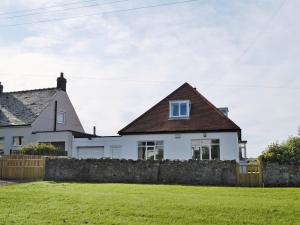 a white house with a fence in the yard at Wayside in Beadnell