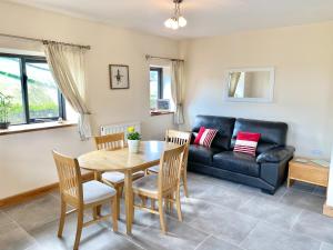 a living room with a table and a couch at Red Kite Cottage in Llangunllo