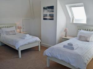 a bedroom with two beds with towels on them at Wayside in Beadnell