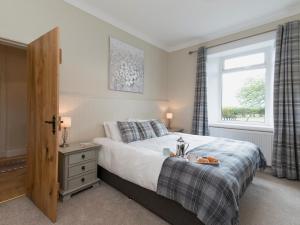 1 dormitorio con cama y ventana en The Den At Culross en Blairhall