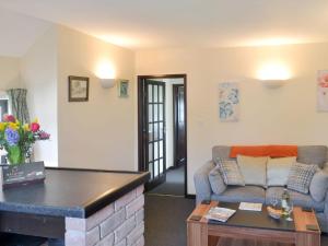 ein Wohnzimmer mit einem Sofa und einem Tisch in der Unterkunft Ramscliff Cottage in Cheddar