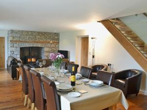 a dining room with a table and chairs and a fireplace at Dolgoed House in Llangadog