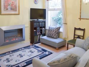 uma sala de estar com um sofá e uma lareira em Dorothy's Cottage em Torquay