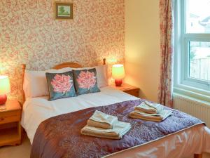 1 dormitorio con 1 cama con toallas en Dorothy's Cottage en Torquay