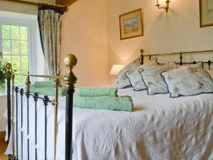 um quarto com uma cama com lençóis brancos e almofadas em The Appleloft em Westleigh