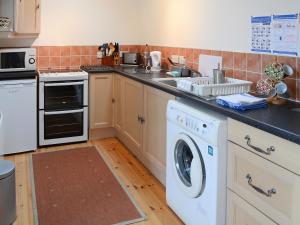 a kitchen with a dishwasher and a washer at Mill Cottage in John O Groats