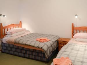 ジョン・オ・グローツにあるMill Cottageのベッドルーム1室(ベッド2台、ベッドにバスローブ付)